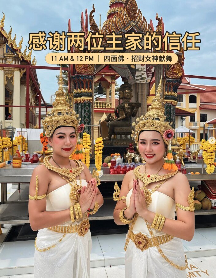 Two MY.Thaidance dancers in white and gold Thai costumes giving a wai greeting at a Four-Faced Buddha shrine before a blessing performance